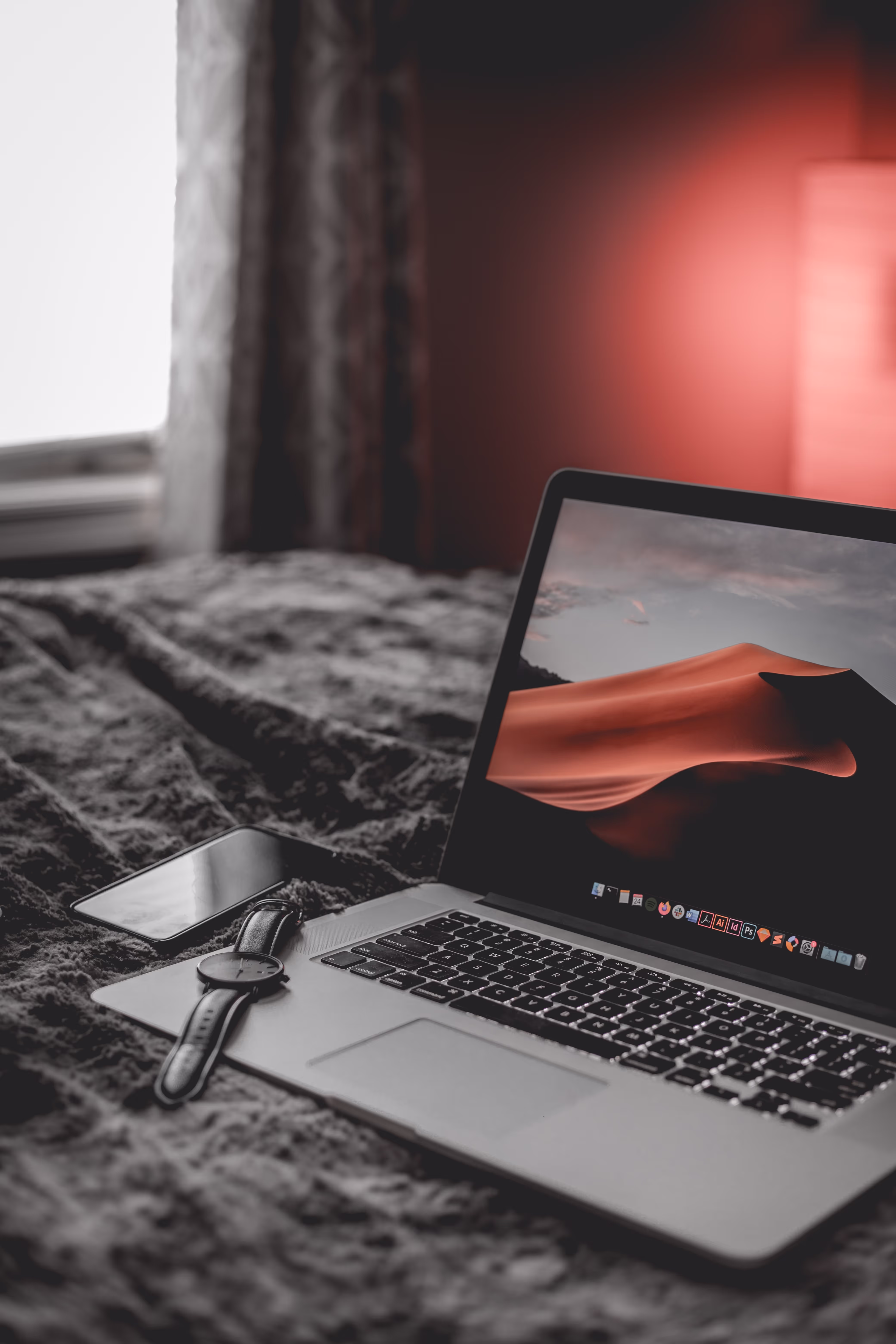 Red aesthetic image of a laptop with a smartphone.
